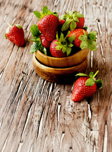 Fresh strawberries in a wooden bowl, selective focus - Photo, image