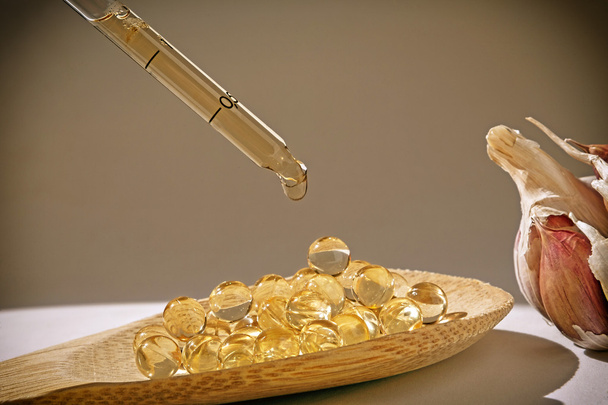 Скляний крапельниця на капсулах часникової олії
 - Фото, зображення