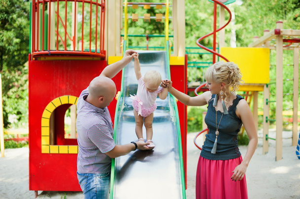 Playful child with parents at the playground outdoor. - Фото, изображение
