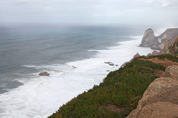 Egy hely, ahol a tenger találkozik a földet. Magas sziklák. Nagy hullám és viharos szél. A Cabo da Roca - Fotó, kép