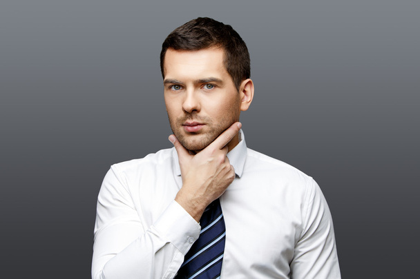Handsome stylish businessman on grey background - Фото, изображение