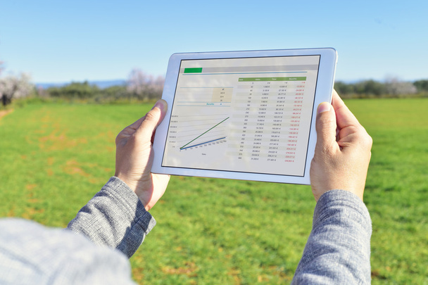 man observing some charts in a tablet in a fallow field - Photo, Image