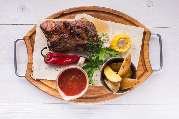 Асорті смачне м'ясо на грилі з овочами над дерев'яною тарілкою
 - Фото, зображення