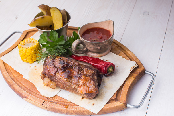 Assorted delicious grilled meat with vegetable over wooden plate - Fotó, kép