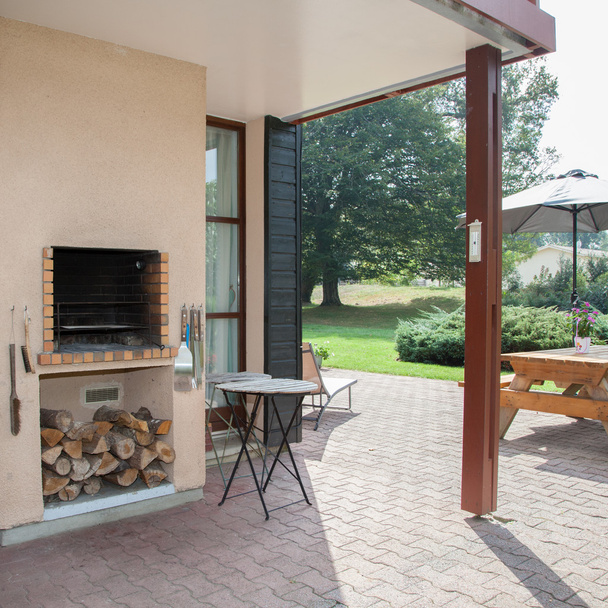 Exterior covered patio with fireplace and furniture. - Photo, Image