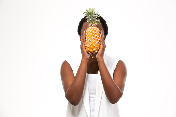 Afrikanisch-amerikanische junge Frau bedeckte ihr Gesicht mit Ananas - Foto, Bild