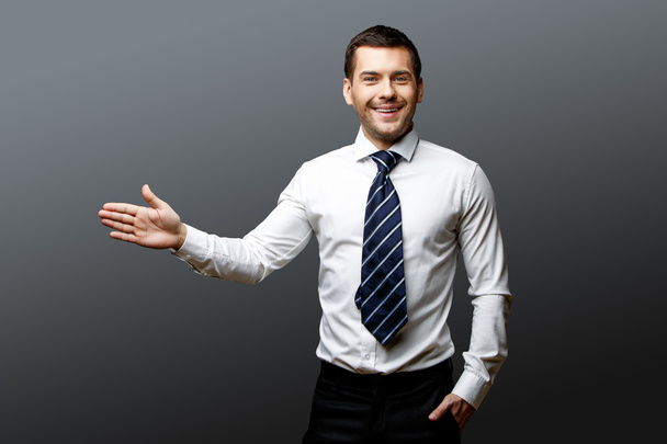 Handsome stylish businessman on grey background - Фото, зображення