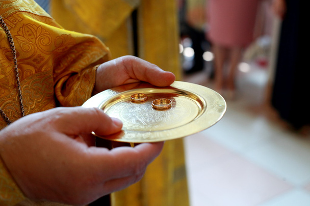 Anneaux de mariage sur une soucoupe d'or dans l'église - Image stock
 - Photo, image