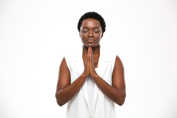 Calm pretty african woman with closed eyes standing and meditating - Foto, Bild