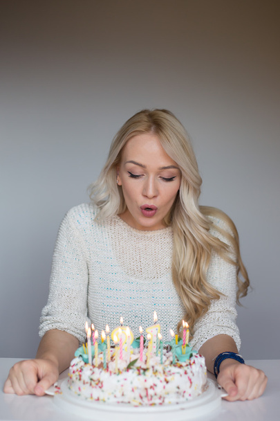bautiful caucasian girl blowing candles on her cake - Photo, Image