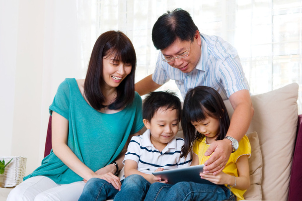 Asian family using tablet computer - Foto, afbeelding