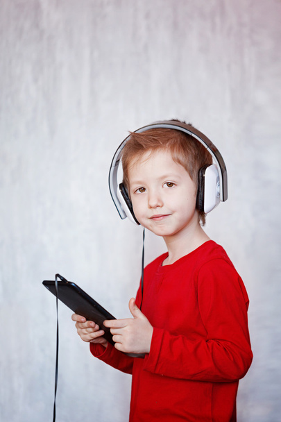 Cute little boy listening to music with headphones and tablet, i - Valokuva, kuva
