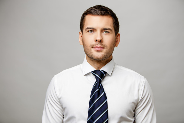Handsome stylish businessman on grey background - Фото, зображення