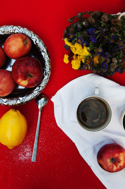 una taza de té, limón amarillo, sobre un fondo rojo, comida y bebida
, - Foto, imagen