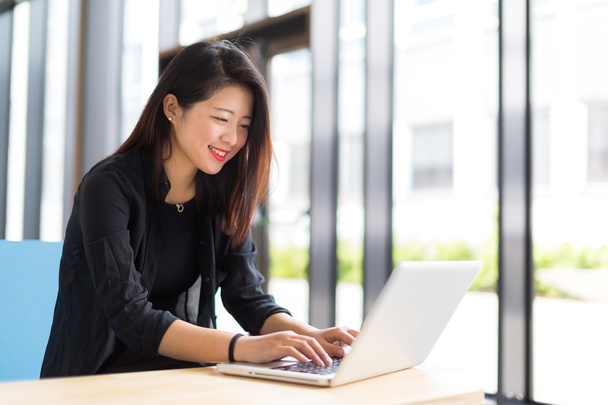 Asiatique collège étudiant assis avec un ordinateur portable sourire
 - Photo, image