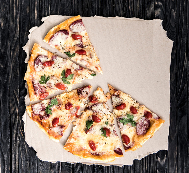 half portions of pizza on parchment - Фото, зображення