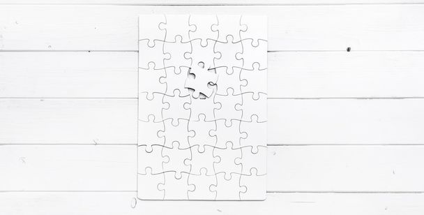white completed puzzle with one undone piece - Photo, image