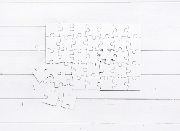 white unfinished puzzle on white table - Zdjęcie, obraz