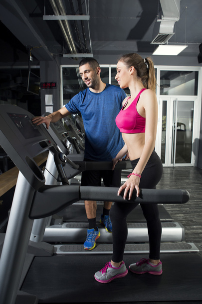 Young woman on treadmill, with instructor - Fotó, kép