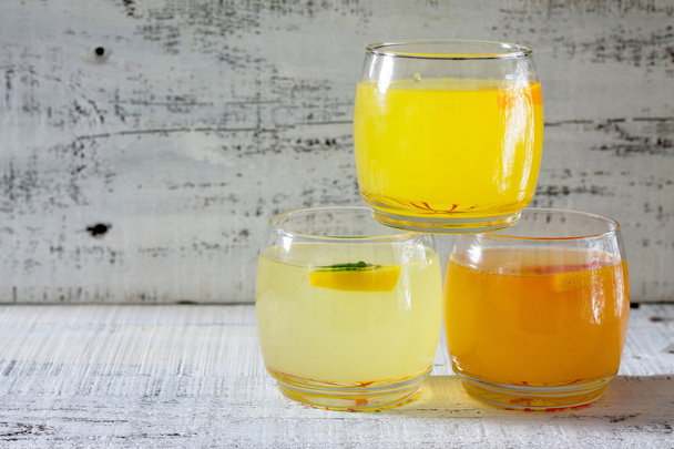 Fresh citrus juices on a white wooden table - Fotografie, Obrázek
