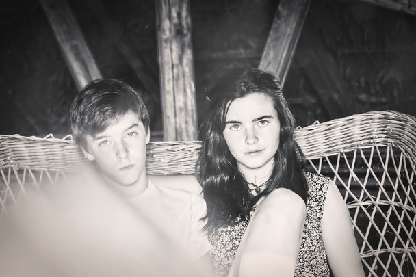 vintage shot of two teenagers sitting on a - Fotografie, Obrázek