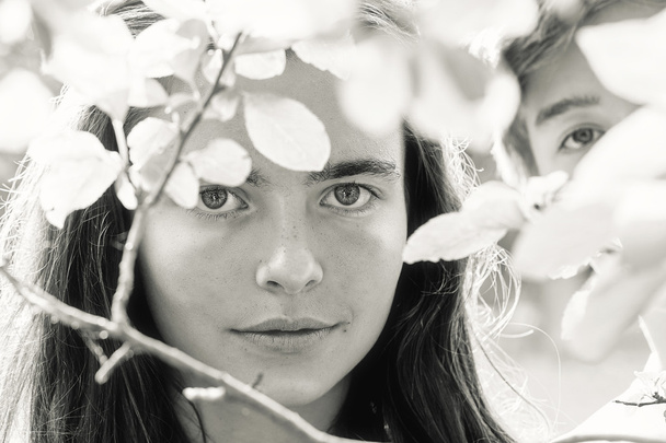 ritratto di due adolescenti dietro alcune foglie
 - Foto, immagini