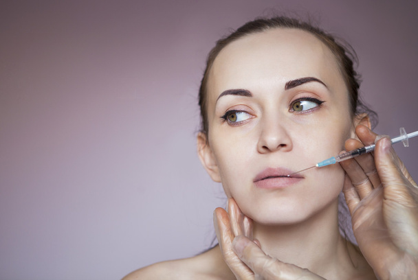 Mujer bonita joven recibiendo inyección cosmética en la cara
 - Foto, Imagen