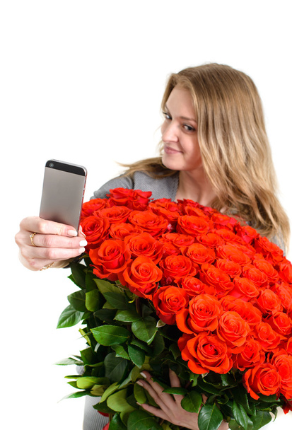 Selfie. Pretty girl photographs the herself with a bouquet of ro - Fotoğraf, Görsel