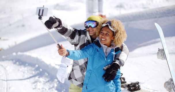 fun couple posing in snow for selfie - Photo, Image