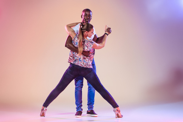Young couple dances social Caribbean Salsa, studio shot - Фото, изображение