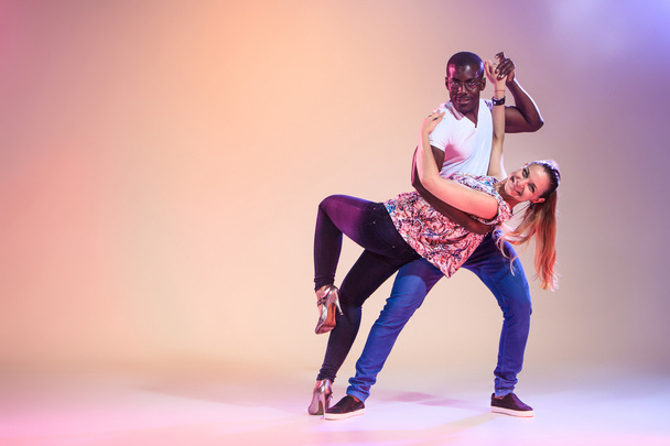 Young couple dances social Caribbean Salsa, studio shot - Фото, зображення