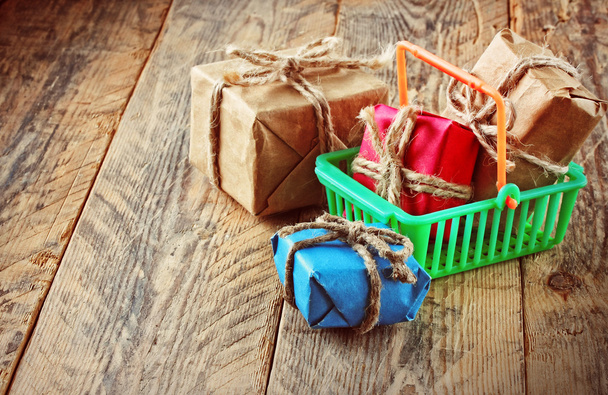 gift boxes in plastic shopping basket - Foto, imagen