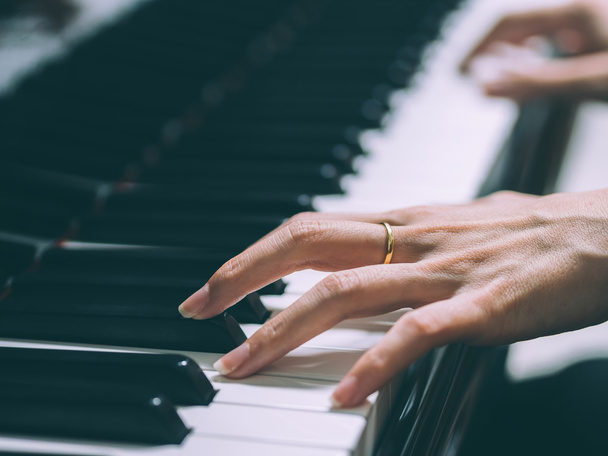 Τα χέρια του μια νεαρή γυναίκα που παίζει πιάνο, επιλεκτική σε κοντινό πλάνο  - Φωτογραφία, εικόνα