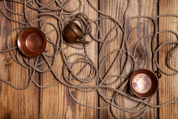 Rope and copper utensils on old wooden burned table or board for - Foto, afbeelding