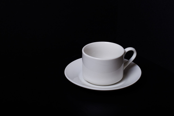 Cup and saucer on a black background - Foto, imagen