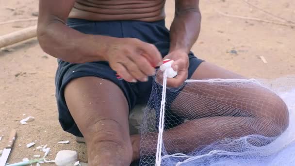 Close-up on fisherman using a fishing net needle for mending a net - Footage, Video