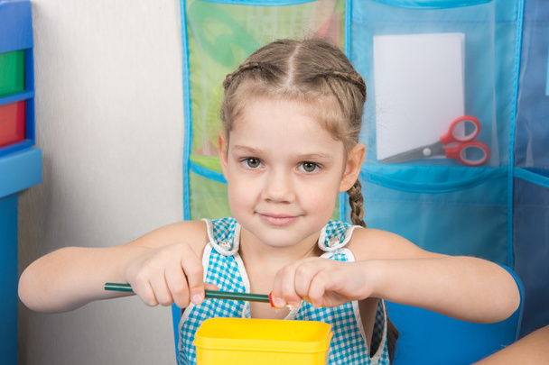 Szczęśliwy 5-letnia dziewczynka wyostrza ołówek ostrzenia małe - Zdjęcie, obraz