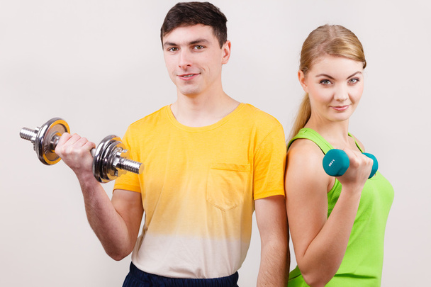 Couple exercising with dumbbells lifting weights  - Photo, Image