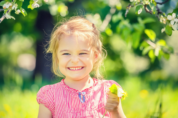 Happy little girl in spring sunny park - Fotó, kép