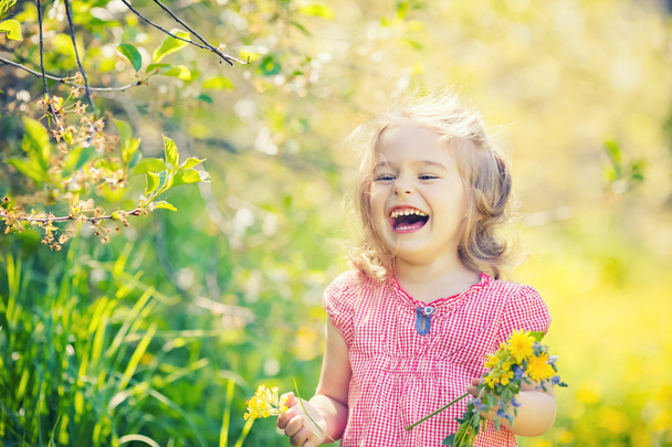 Happy little girl in spring sunny park - Фото, зображення