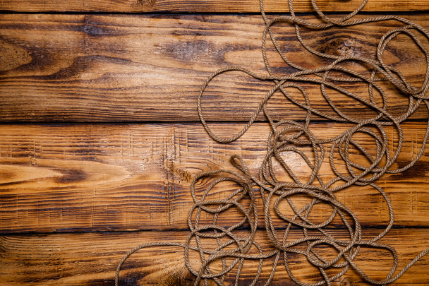 Rope on old wooden burned table or board for background. Toned - Zdjęcie, obraz