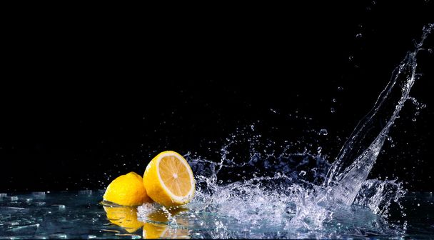 Sliced lemon in the water on black background - Zdjęcie, obraz