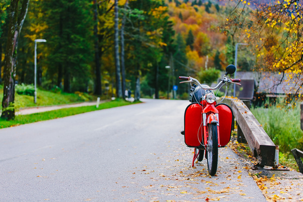 Vintage moto scooter rojo cerca del lago Bohinj, Eslovenia. Colorida escena otoñal
. - Foto, Imagen