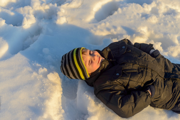 Criança que estabelece na neve
 - Foto, Imagem