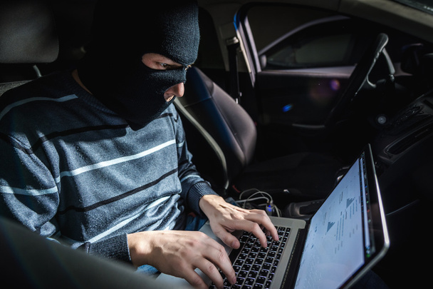 Κλέφτης με ένα φορητό υπολογιστή μέσα σε ένα αυτοκίνητο - Φωτογραφία, εικόνα