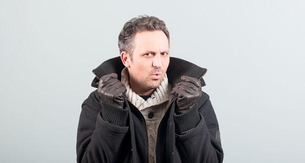 Sexy man frodrinking en houden van zijn jas kraag - Foto, afbeelding