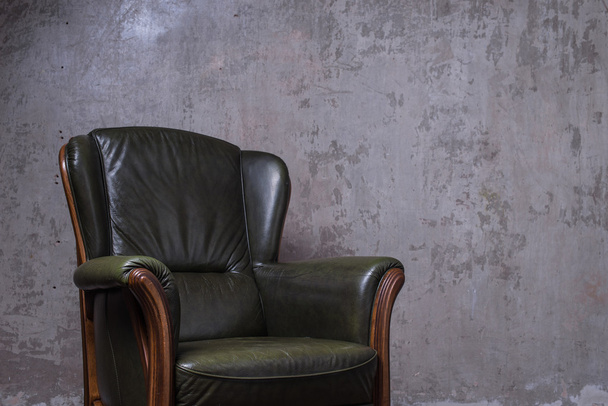 Green leather armchair in front of the wall - Fotó, kép