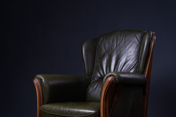 Зеленое кожаное кресло перед стеной
 - Фото, изображение