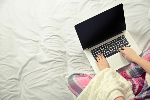 Woman in pajamas with laptop - 写真・画像