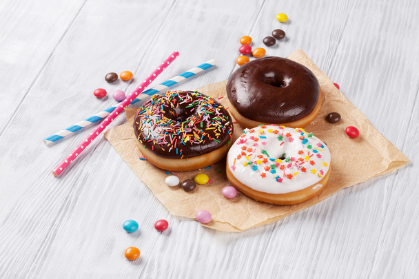 Colorful donuts on wooden table - Photo, Image